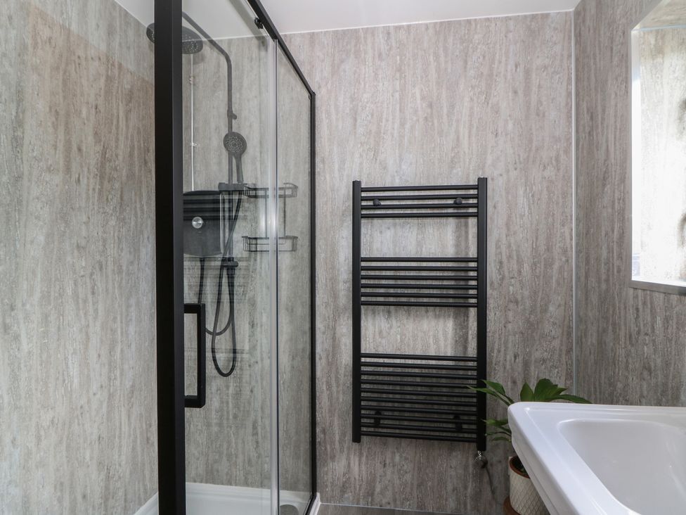 A bathroom with a shower and towel radiator at Red Kite Cottage Howey near Llandrindod Wells