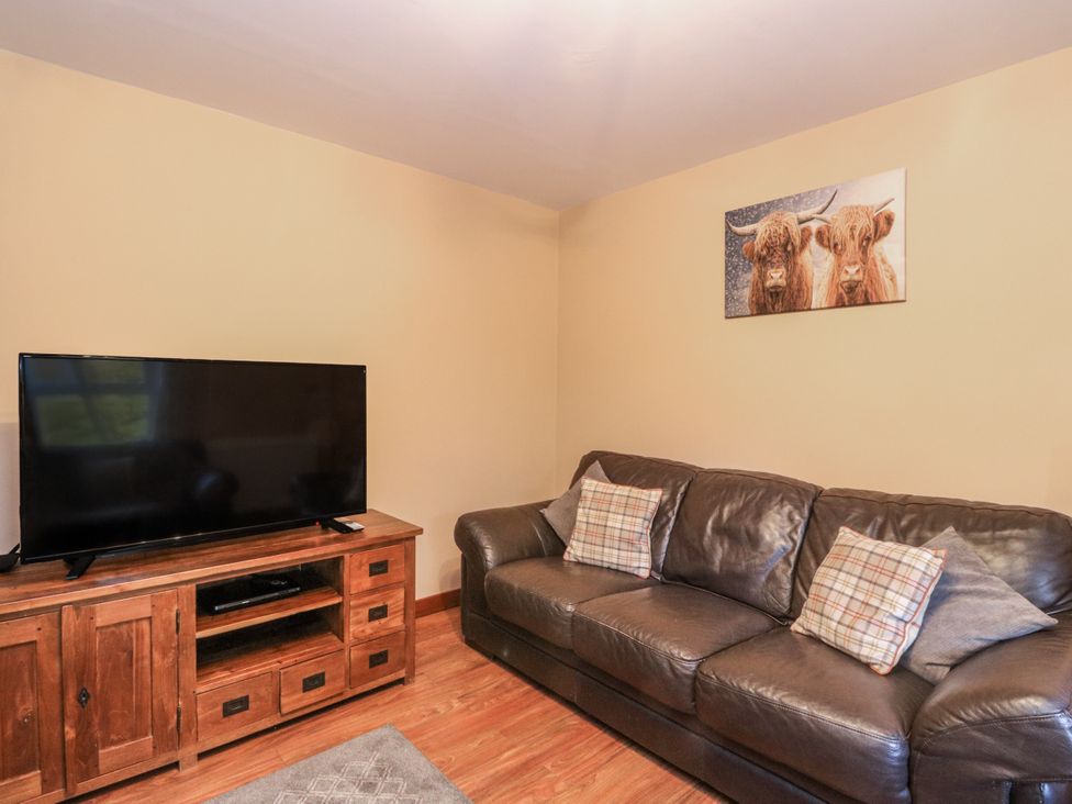 A living room with a television and sofa at Deskford Cottage in Nairn