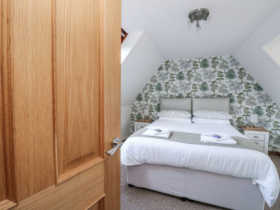 A bedroom with a double bed and bedside tables at Deskford Cottage in Nairn