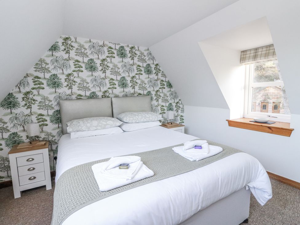 A bedroom with a bed and nightstand at Deskford Cottage Nairn