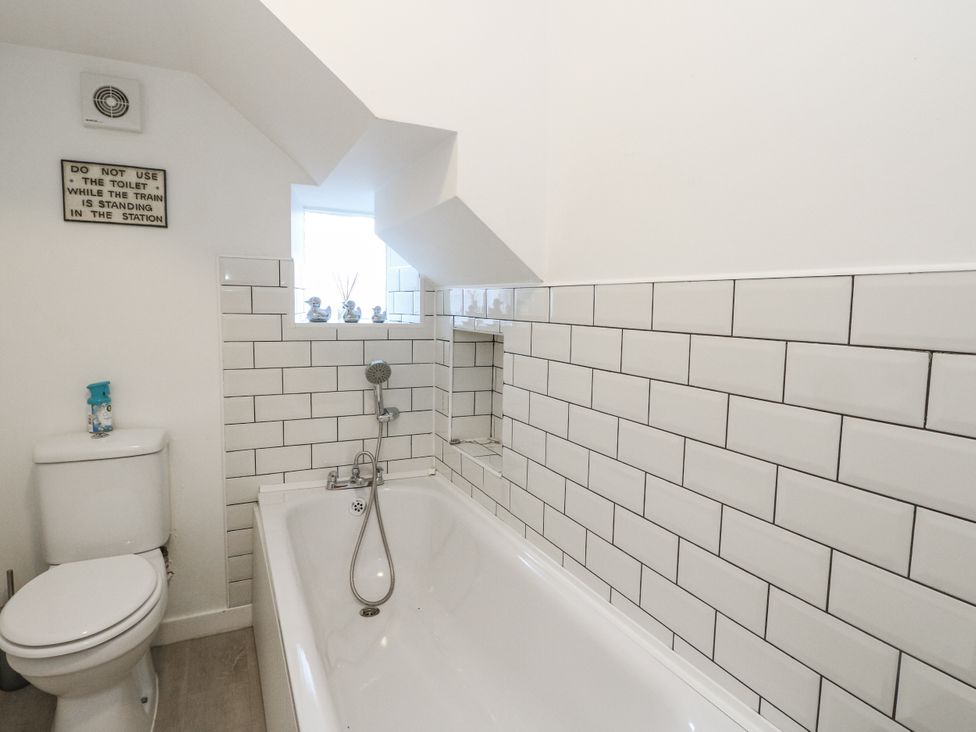 A bathroom with a bathtub and toilet at Deskford Cottage in Nairn