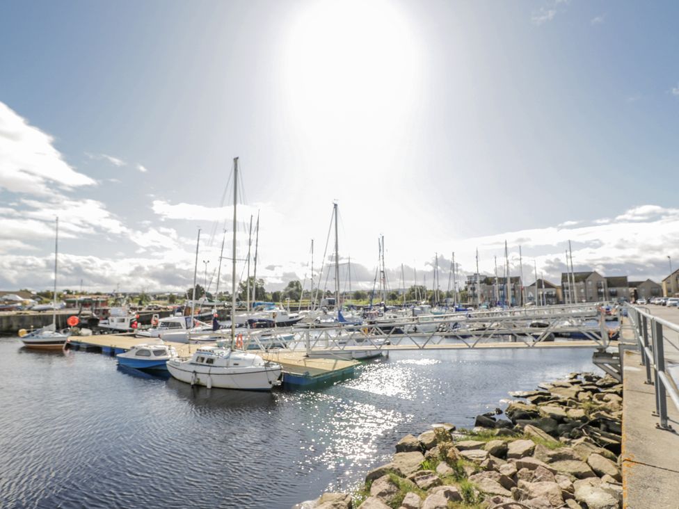 A marina with boats moored and a dock at Deskford Cottage in Nairn