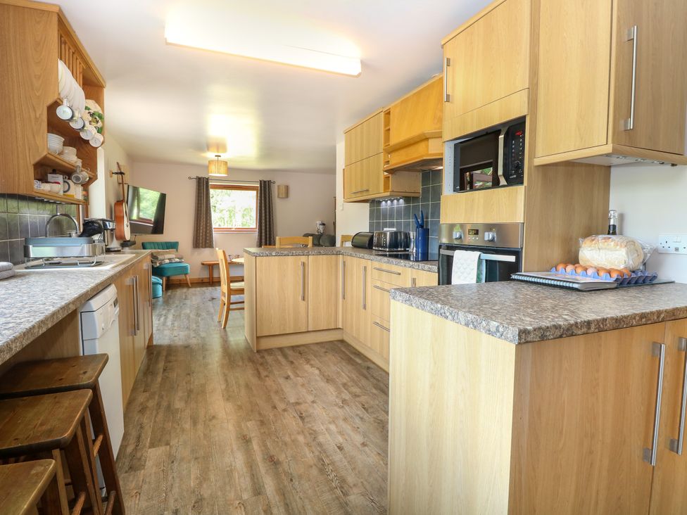 A kitchen with appliances and seating area at Dragonfly Lodge Whinburgh near Dereham