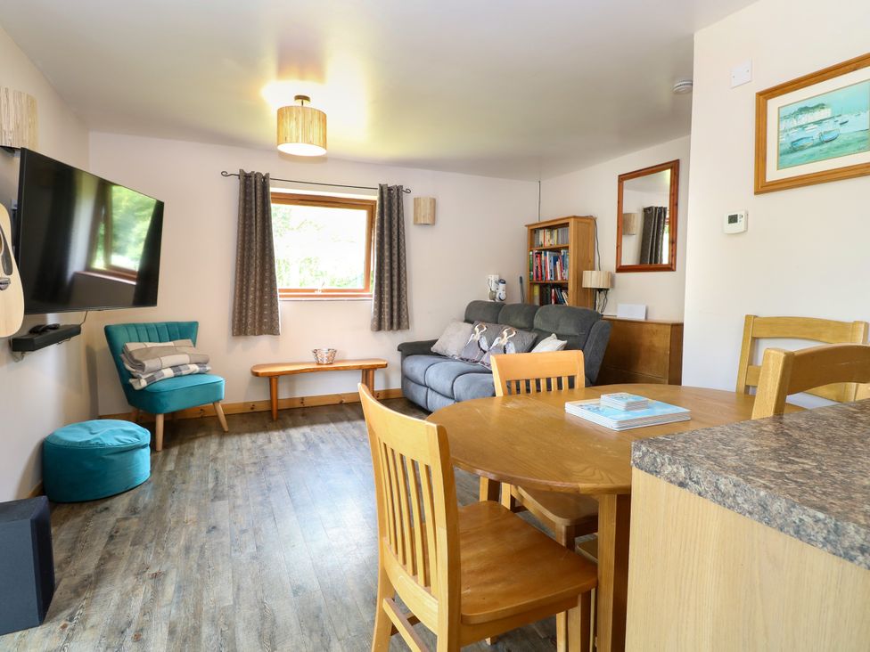 A living room with a sofa and dining table at Dragonfly Lodge Whinburgh near Dereham