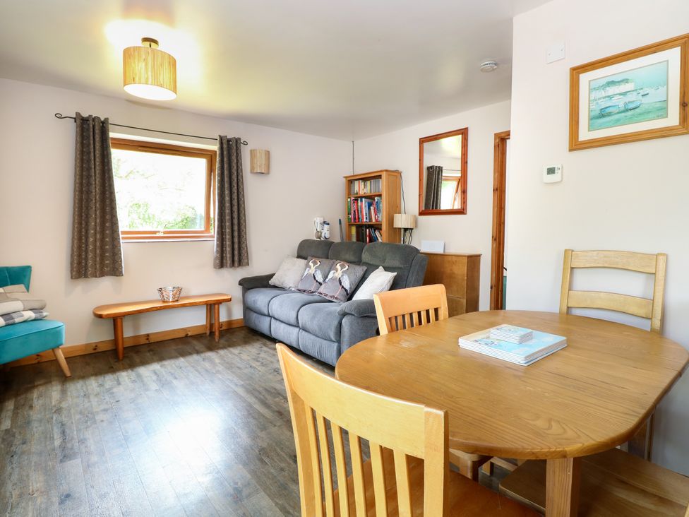 A living room with a sofa and dining table at Dragonfly Lodge in Whinburgh near Dereham