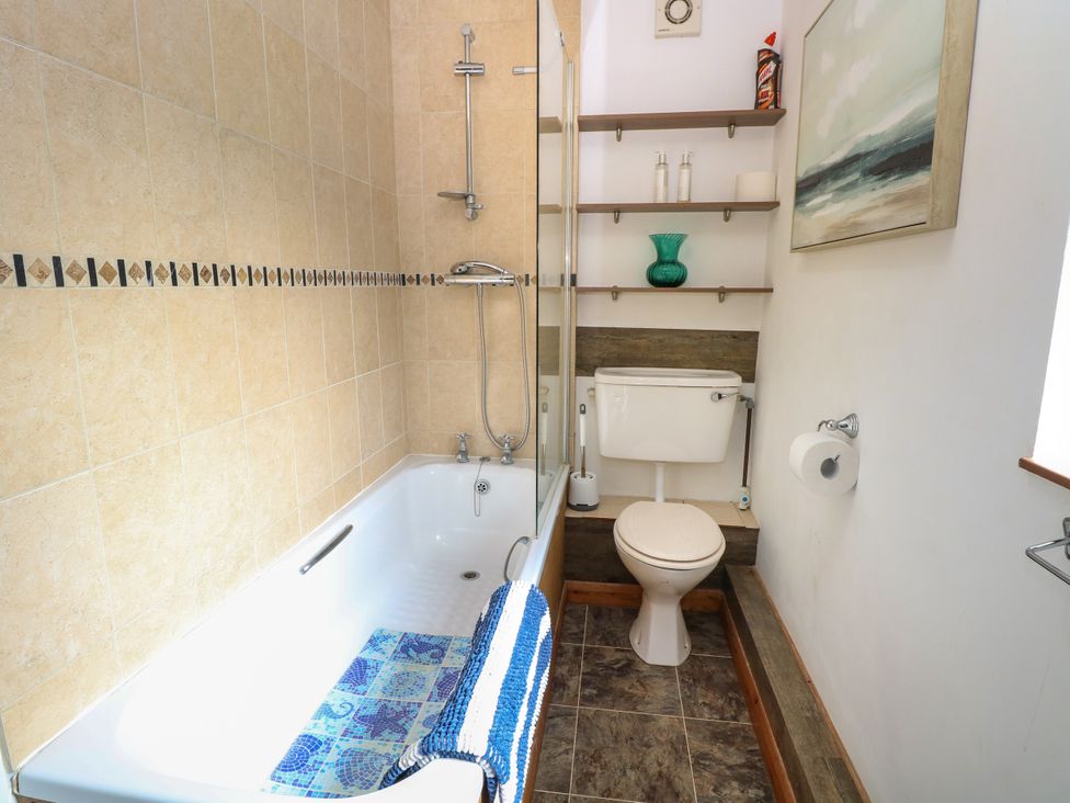 A bathroom with a bathtub, toilet, and sink at Dragonfly Lodge in Whinburgh near Dereham