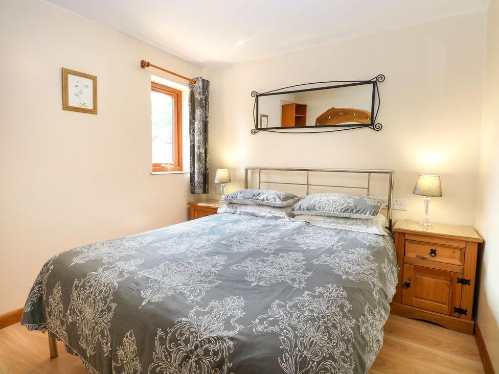 A bedroom with a bed and bedside tables at Dragonfly Lodge in Whinburgh near Dereham