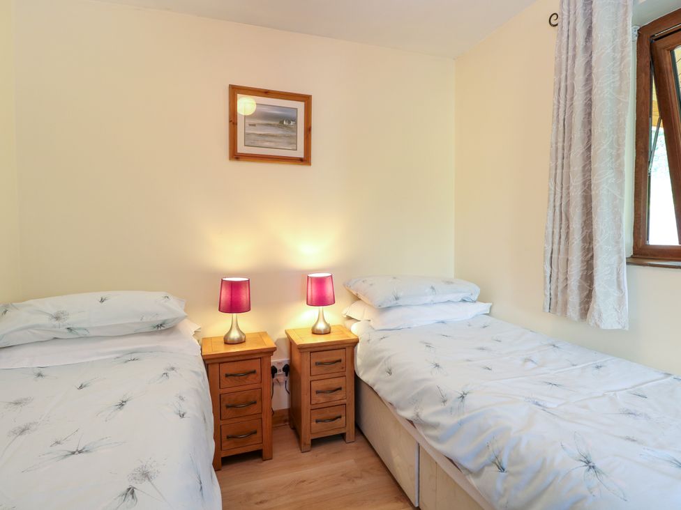 A bedroom with two beds and lamps at Dragonfly Lodge in Whinburgh near Dereham