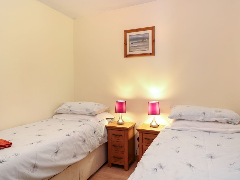 A bedroom with two beds and nightstands at Dragonfly Lodge in Whinburgh near Dereham