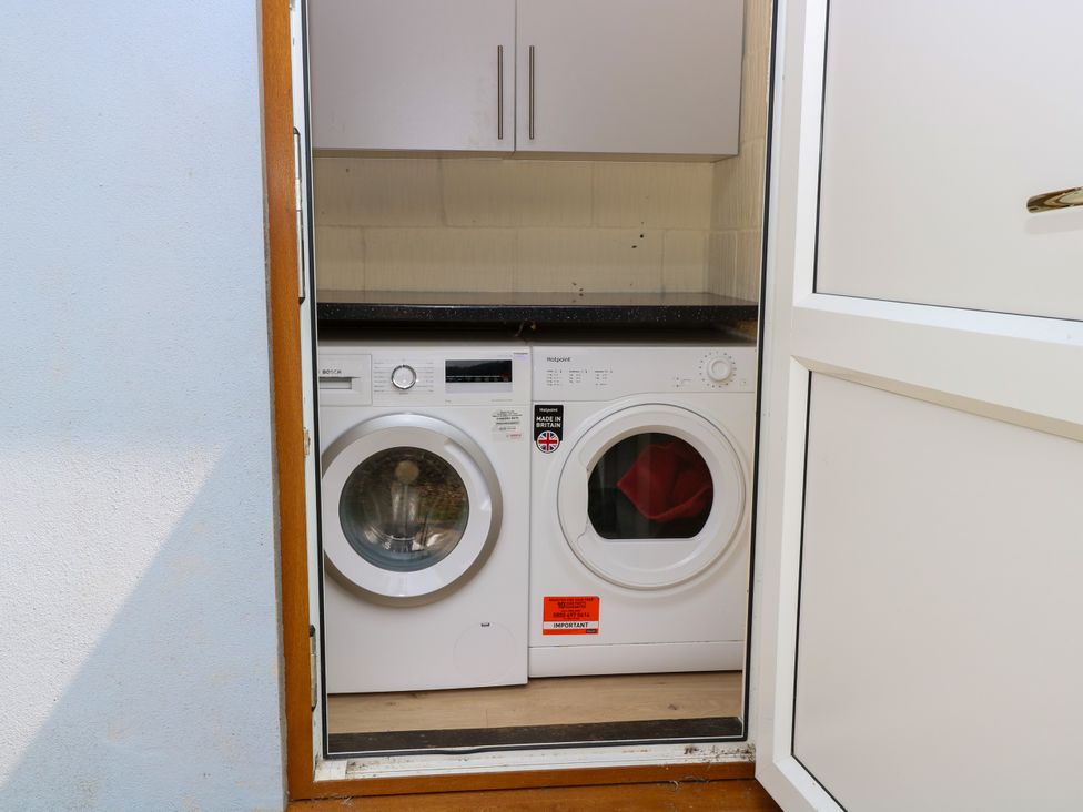 A laundry room with a washing machine and dryer at Dragonfly Lodge Whinburgh near Dereham