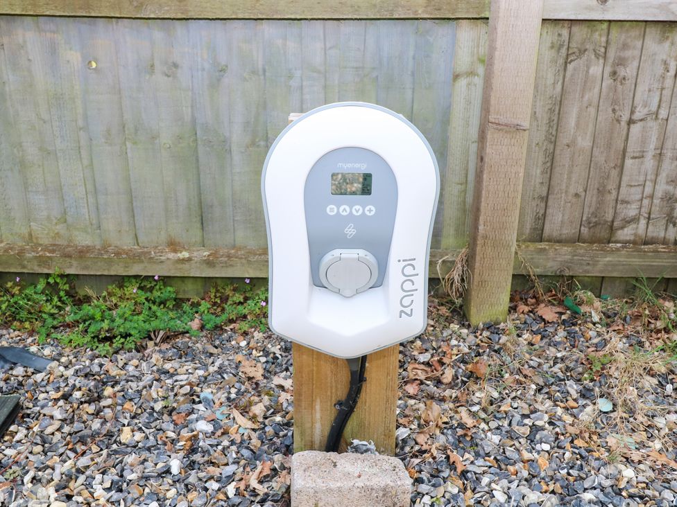 An electric vehicle charger mounted on a post in an outdoor area at Dragonfly Lodge in Whinburgh near Dereham