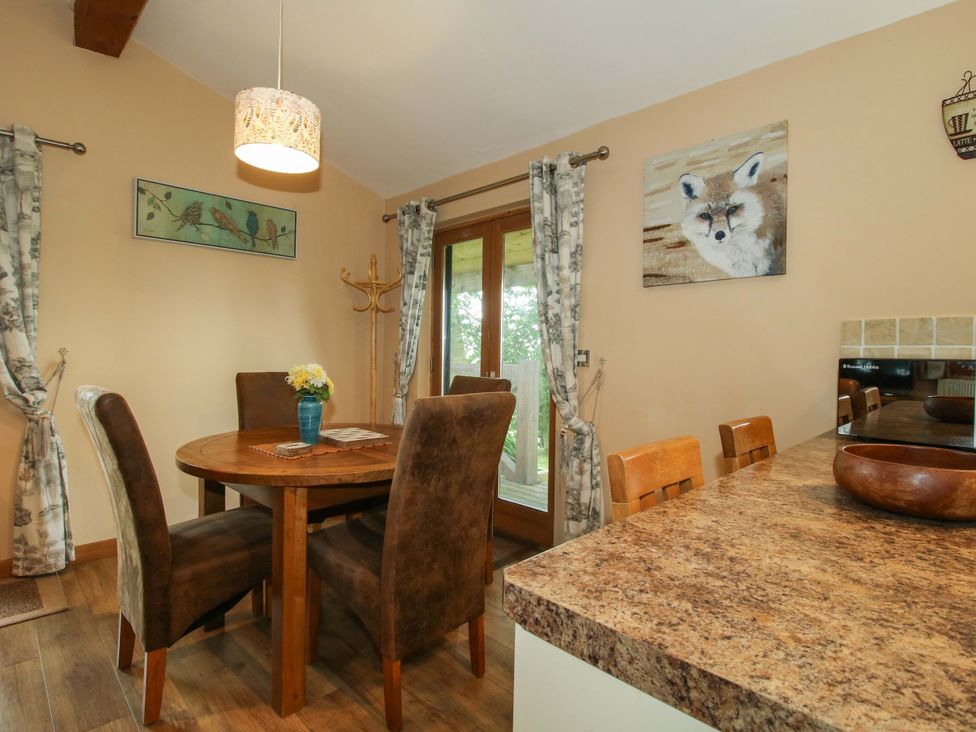 A dining room with a wooden table and chairs at Valley View Lodge Welshpool