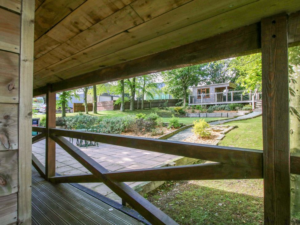A view of a garden with a shed from a wooden structure at Valley View Lodge in Welshpool