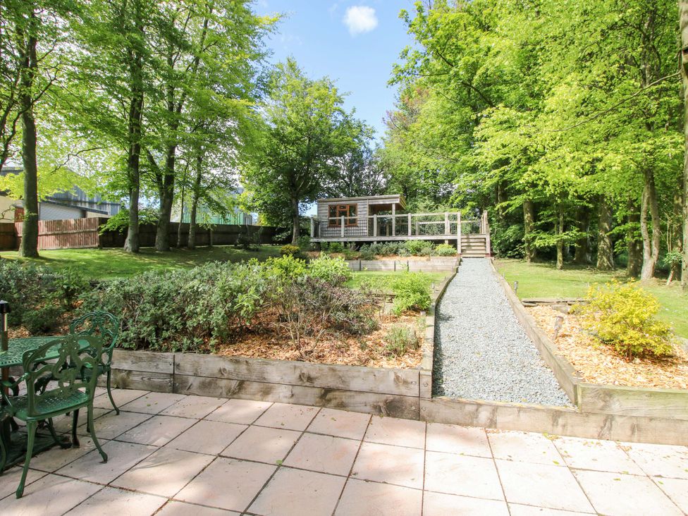 A garden with a gravel path leading to a wooden structure at Valley View Lodge in Welshpool