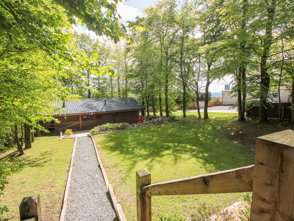 A view of a lodge surrounded by trees and a pathway at Valley View Lodge in Welshpool