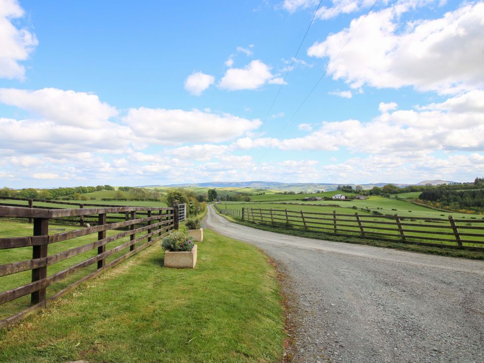 A landscape view with a driveway and fence at Valley View Lodge in Welshpool
