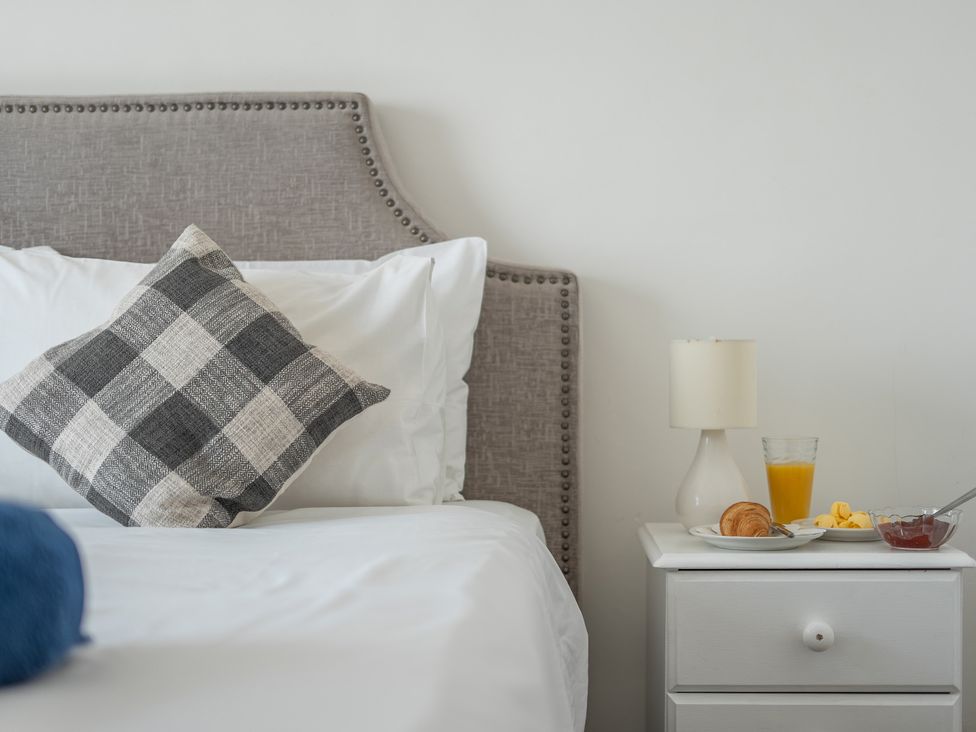 A bedroom with a bed and breakfast items on a nightstand at The Lookout in Sennen