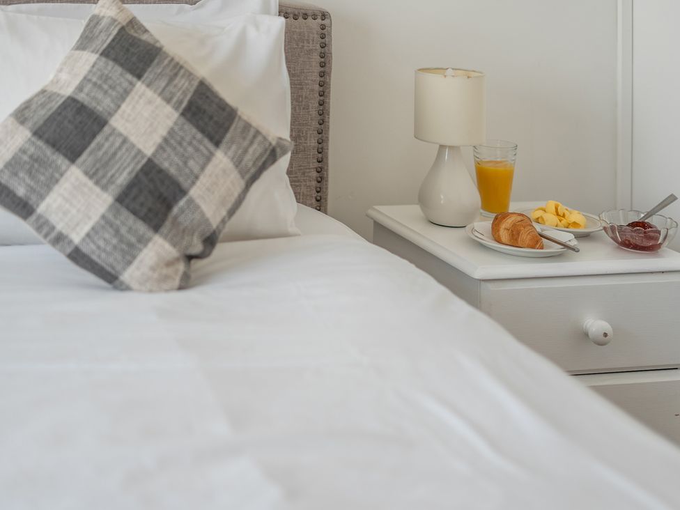 A bedroom with a pillow and breakfast items on a nightstand at The Lookout in Sennen