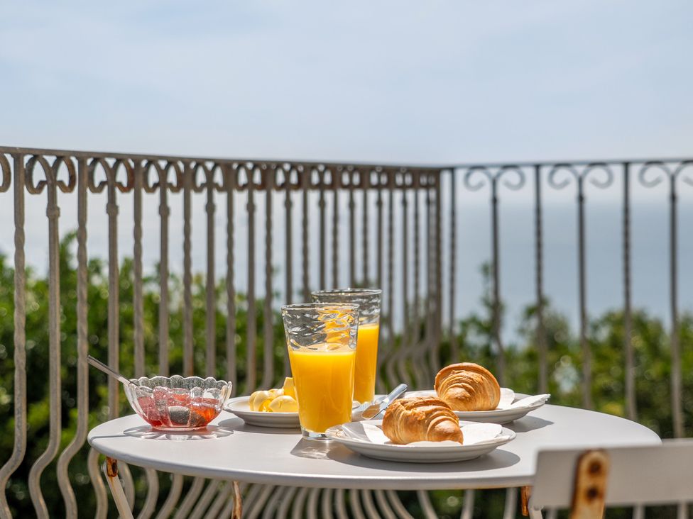 A table with orange juice and croissants on a balcony at The Lookout in Sennen