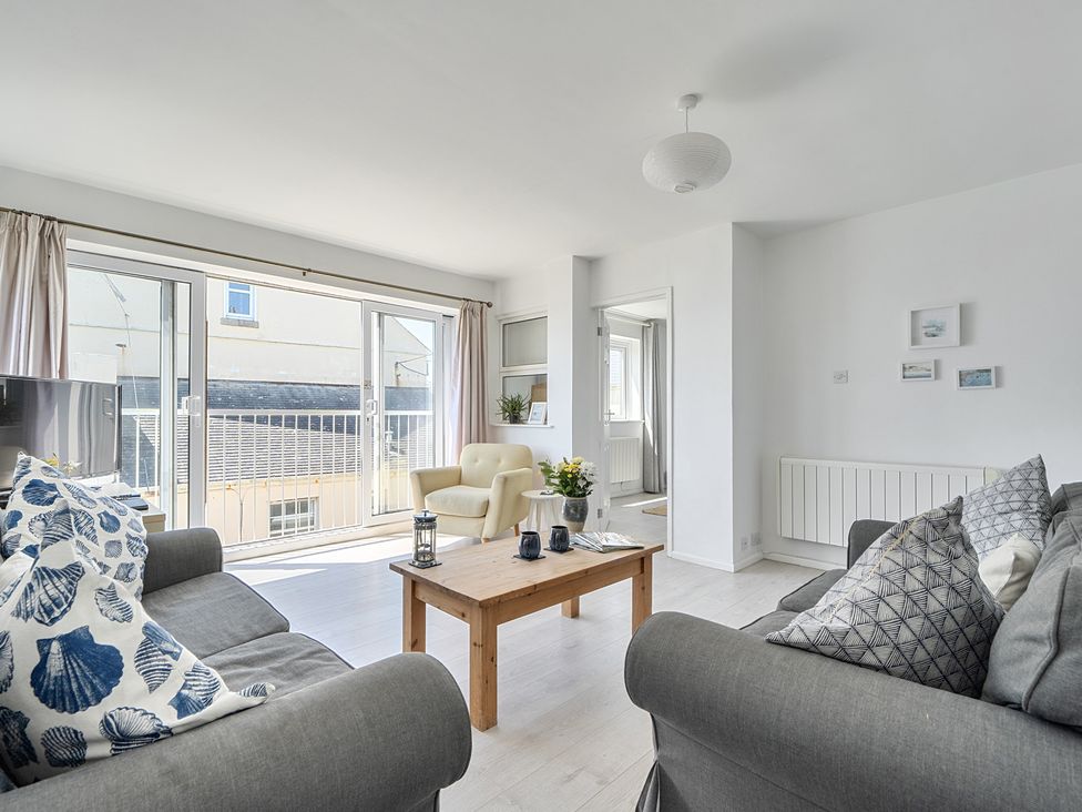 A living room with a sofa and chair at Brook House in Sennen Cove near St Just