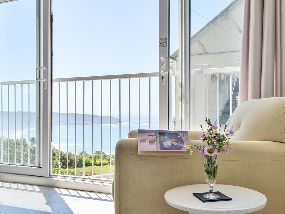 A living room with a sofa and glass table at Brook House Sennen Cove near St Just