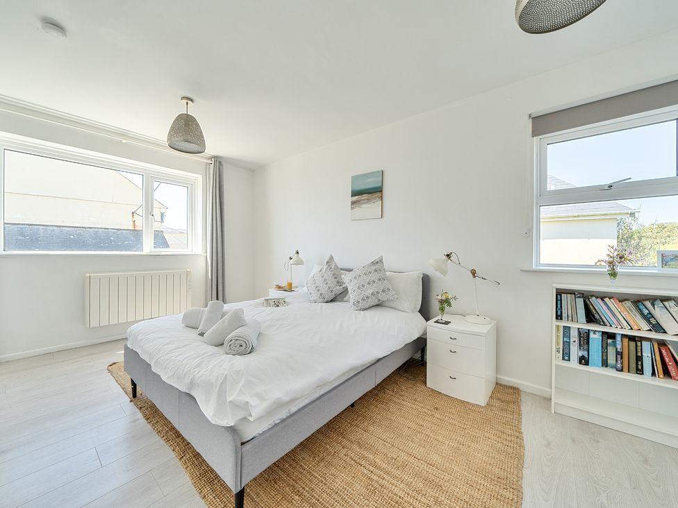 A bedroom with a double bed and bookshelf at Brook House Sennen Cove near St Just