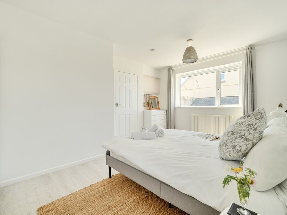 A bedroom with a bed and window at Brook House in Sennen Cove near St Just