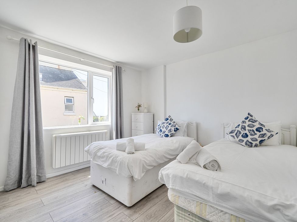 A bedroom with two beds and a window at Brook House Sennen Cove near St Just