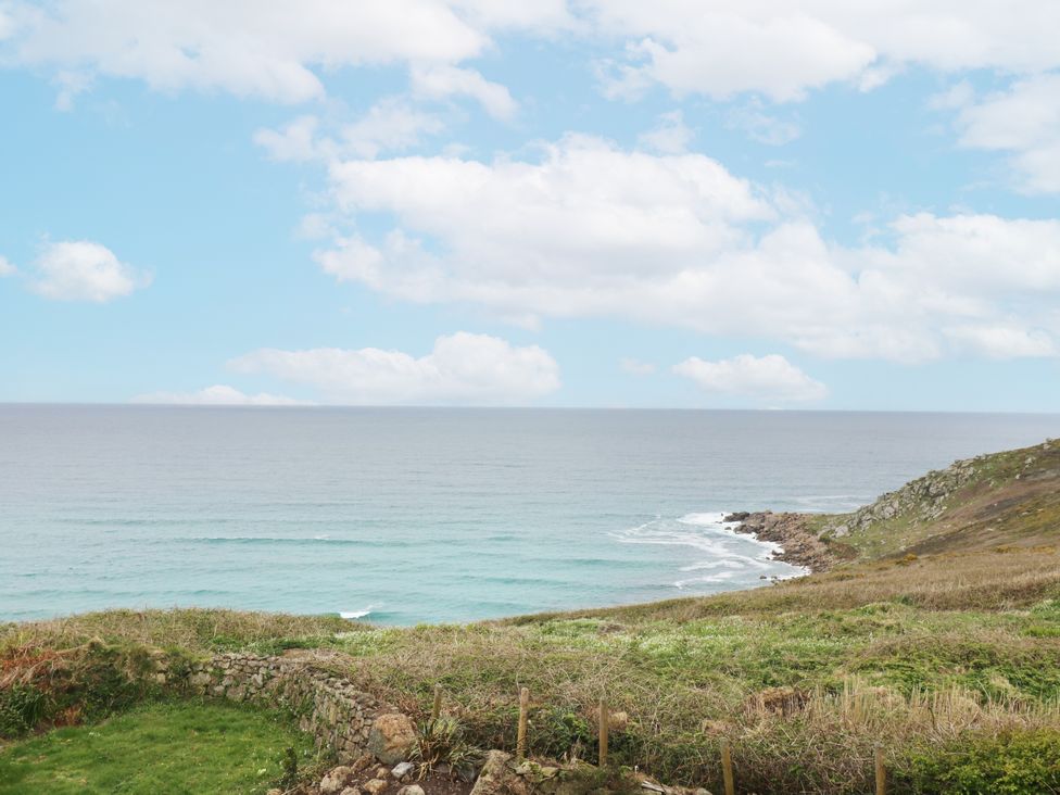 A view of the ocean with clouds and land at The Coach House in Sennen near St Just