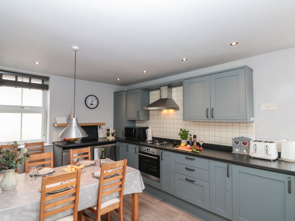 A kitchen with a dining table and appliances at Kirkby House in Whitby