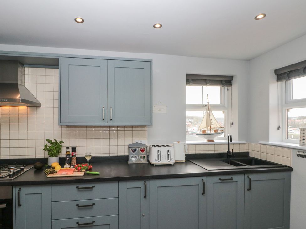 A kitchen with cabinets, sink, and utensils at Kirkby House in Whitby