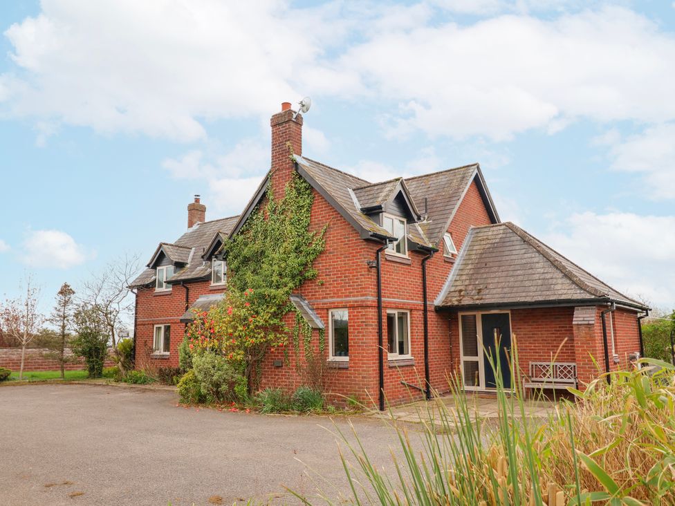 A house with a brick exterior and multiple windows at Manor Wood Farndon