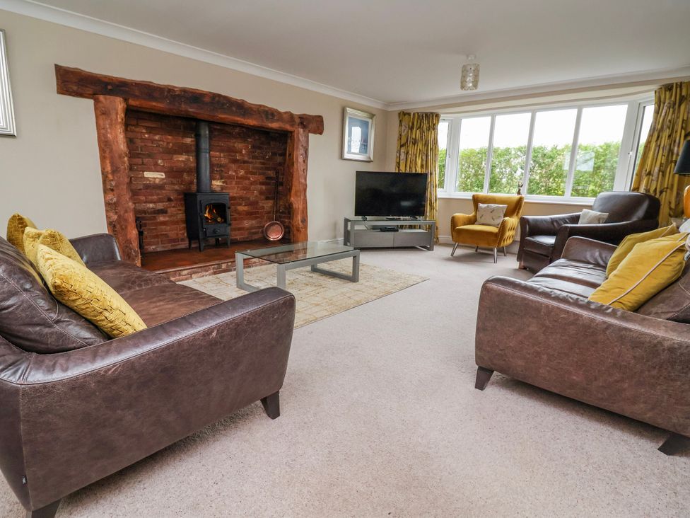 A living room with furniture and a fireplace at Manor Wood in Farndon