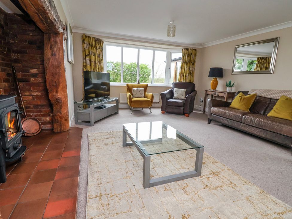 A living room with a fireplace and television at Manor Wood in Farndon