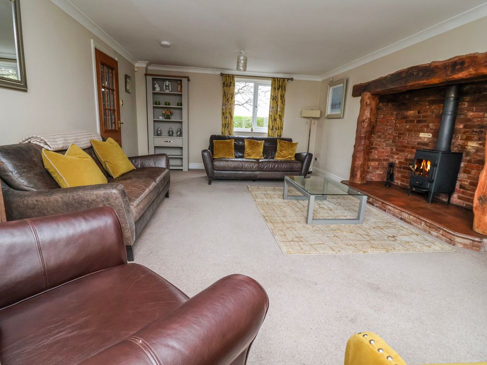 A living room with a fireplace, sofa, and coffee table at Manor Wood in Farndon