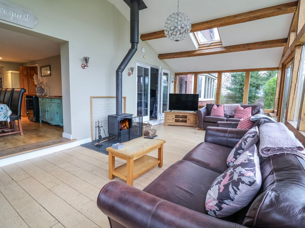 A conservatory with a sofa and coffee table at Manor Wood in Farndon