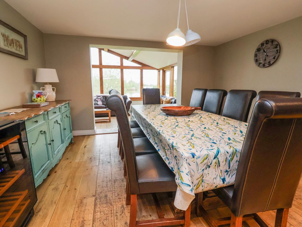 A dining room with a large table and chairs at Manor Wood in Farndon