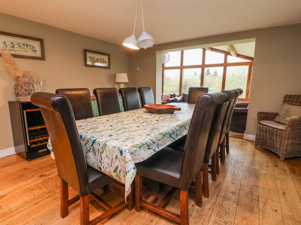 A dining room with a large table and chairs at Manor Wood in Farndon
