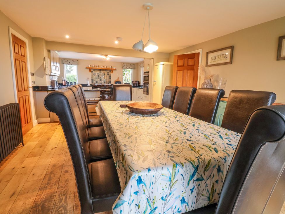A dining room with a large table and chairs at Manor Wood in Farndon