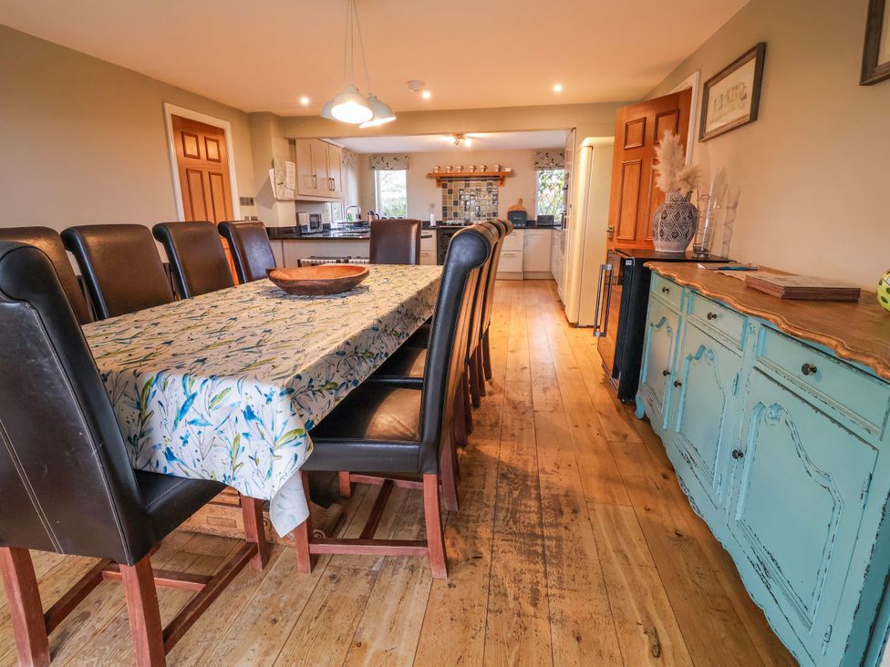 A dining room with a table and chairs at Manor Wood in Farndon