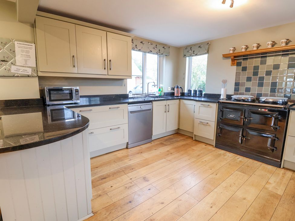 A kitchen with appliances and cabinets at Manor Wood in Farndon