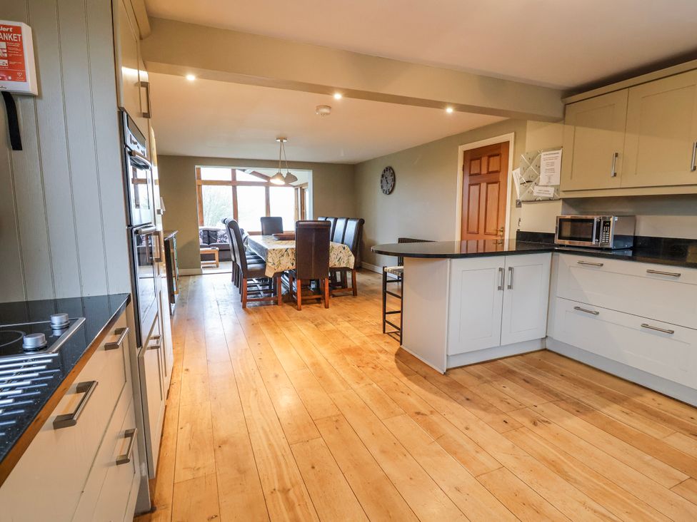 A kitchen with a dining area and appliances at Manor Wood in Farndon