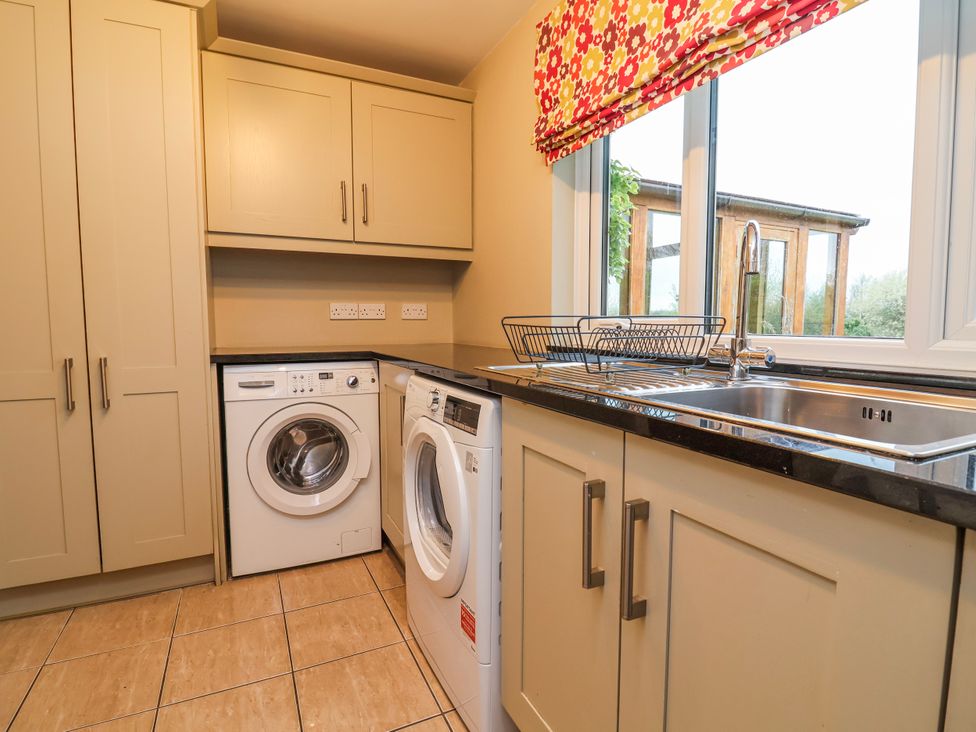 A laundry room with a washing machine and dryer at Manor Wood in Farndon