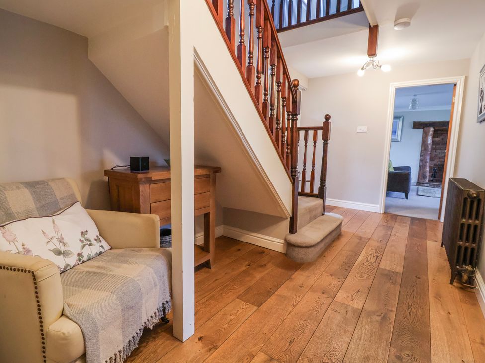 A hallway with a staircase and a sofa at Manor Wood in Farndon