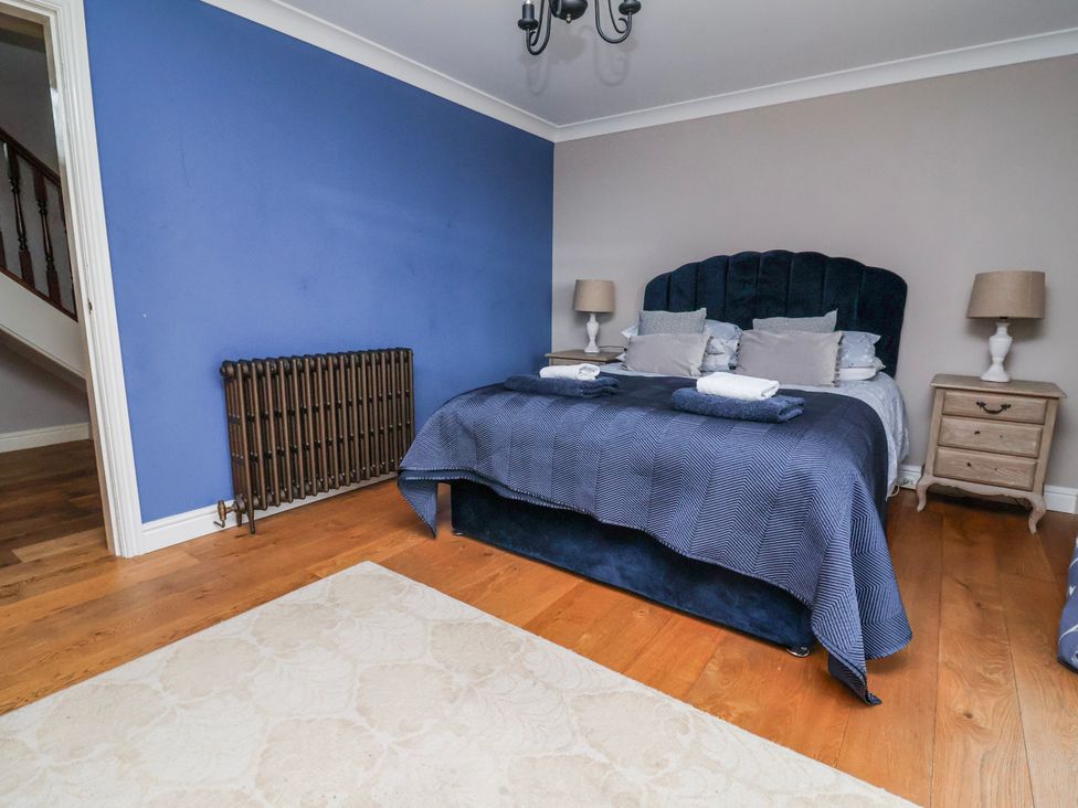 A bedroom with a bed and nightstand at Manor Wood in Farndon