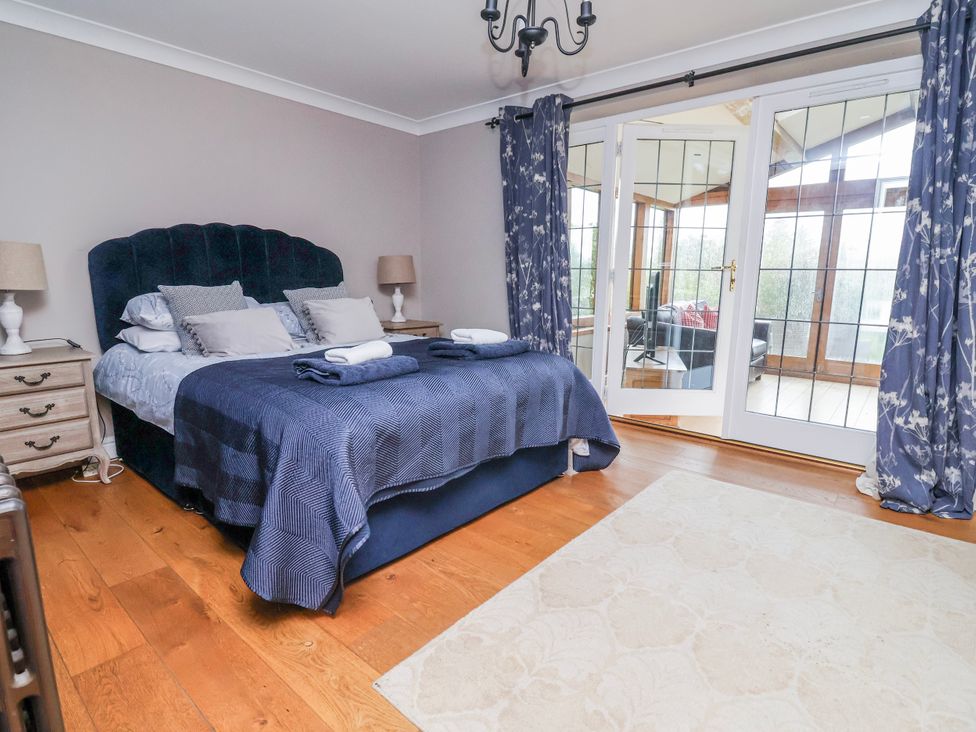 A bedroom with a bed and door leading to another room at Manor Wood in Farndon