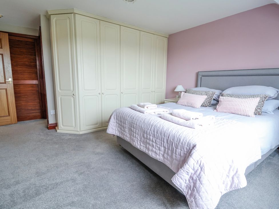 A bedroom with a bed and wardrobe at Manor Wood in Farndon