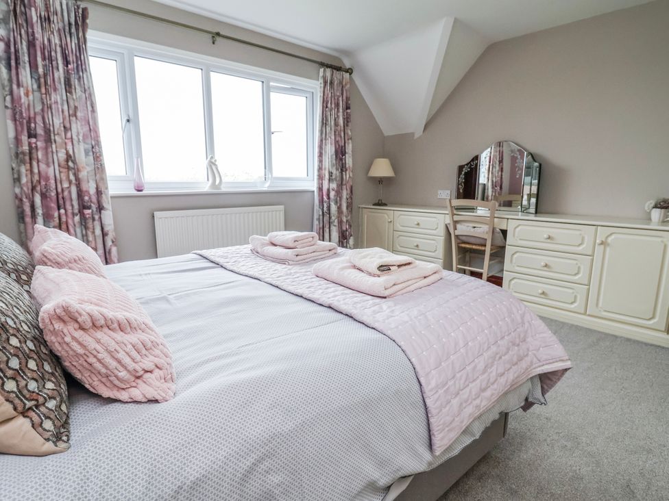 A bedroom with a bed and dresser at Manor Wood in Farndon