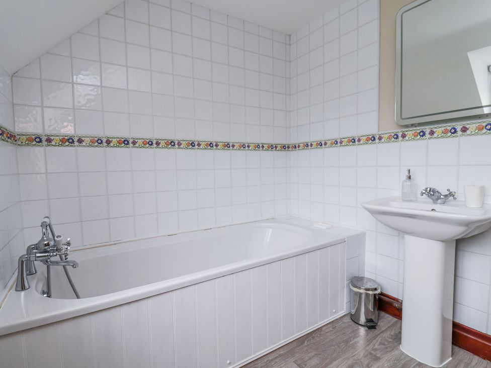 A bathroom with a bath tub and sink at Manor Wood in Farndon