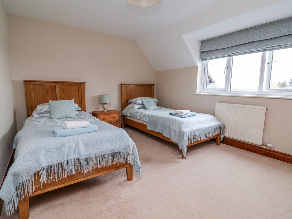 A bedroom with two single beds and a window at Manor Wood in Farndon